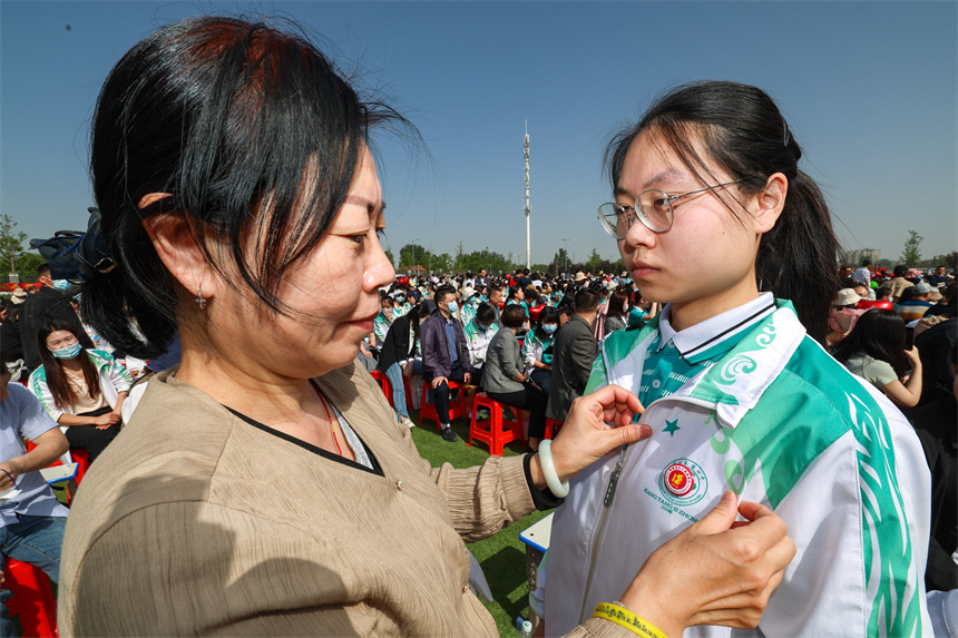 家長給孩子佩戴成人徽章。 