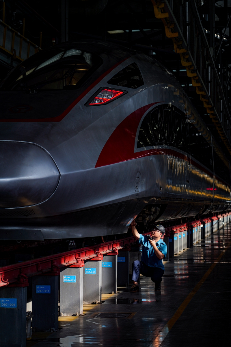 動(dòng)車組機(jī)械師在對列車進(jìn)行檢修。鄒政攝 