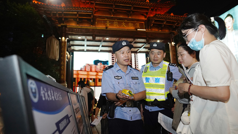 7月7日小暑時(shí)節(jié)，武昌區(qū)公安分局漢街派出所民警冒著夏日的炎炎高溫在漢街大戲臺(tái)向來(lái)往游客宣傳防騙禁毒知識(shí)。孫遜攝