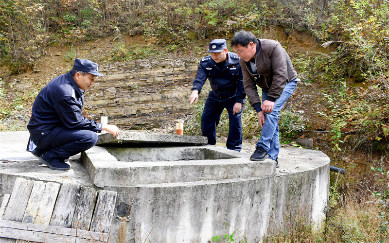 ?？倒柴v村工作隊(duì)民警踏查村民蓄水池。