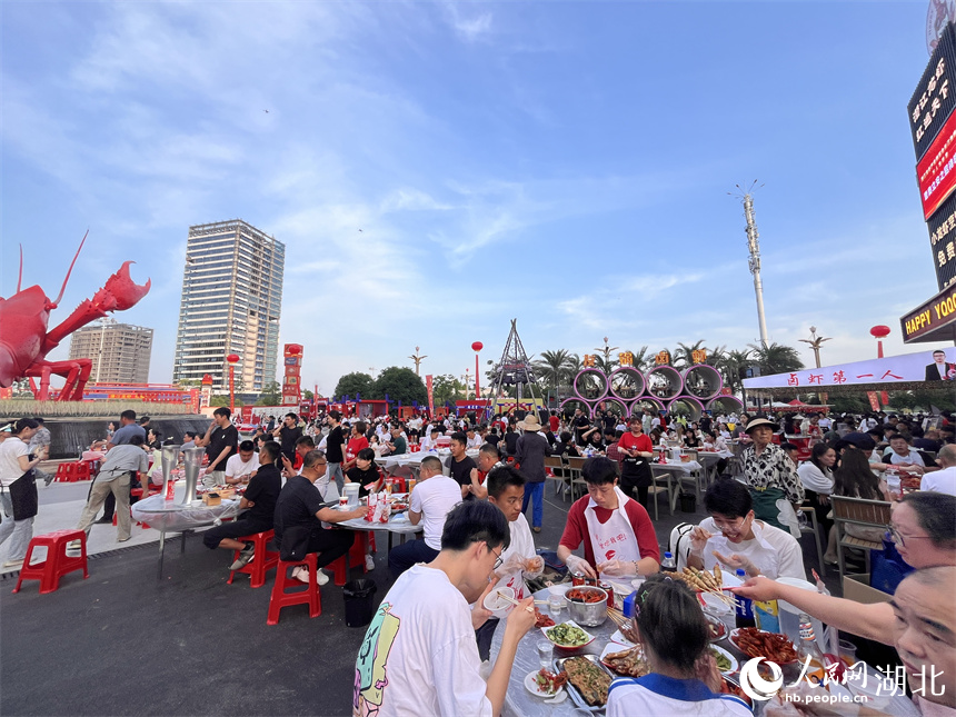 三五成群的食客手口并用，大快朵頤，品嘗著一盤盤色澤飽滿、醇香味美的小龍蝦。人民網記者 張雋攝