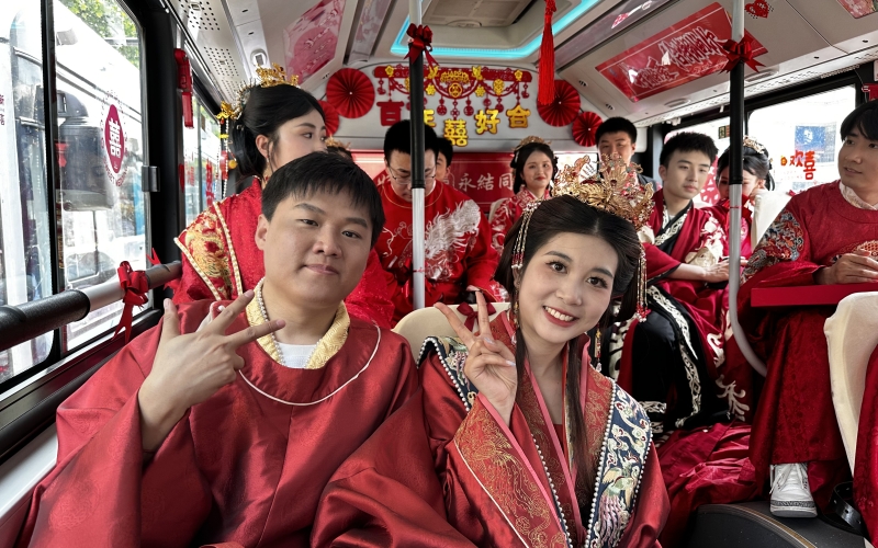 新人集體乘坐公交婚車，踐行低碳環(huán)保新風(fēng)尚。