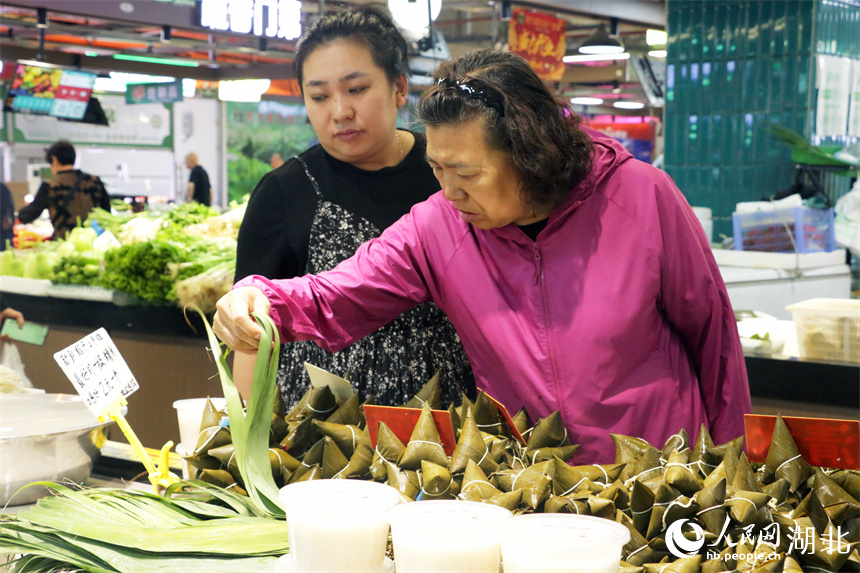 端午將至，洪山廣場地鐵站菜市場擺出了粽葉、手工粽子等節(jié)日美食，供市民挑選。人民網(wǎng)記者 周恬攝