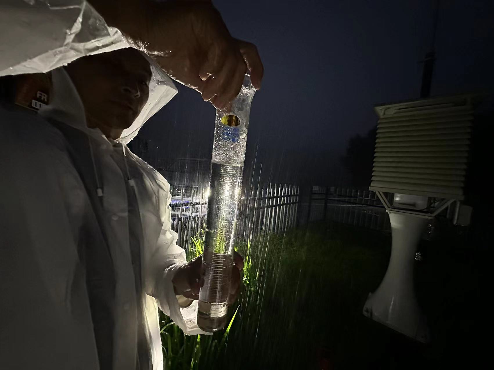 氣象觀測(cè)員雨夜核查觀測(cè)站降水量。朱慧麗攝