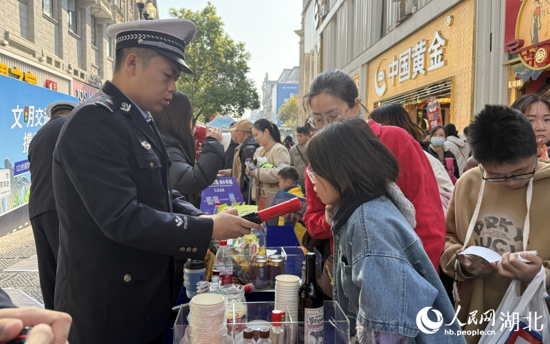 市民在拒絕酒駕體驗(yàn)攤位對著酒精檢測儀吹氣。人民網(wǎng)記者 周恬